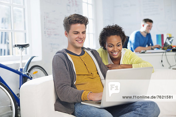 Business people using laptop in office