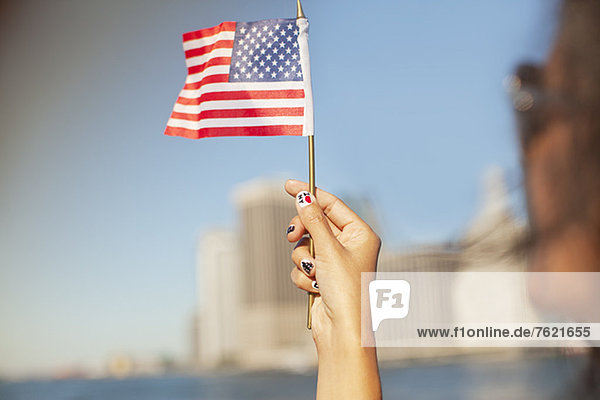 Woman with novelty nails waving American flag
