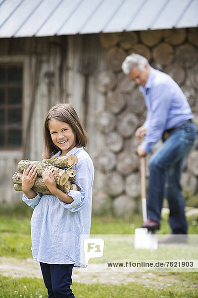Girl carrying firewood outdoors