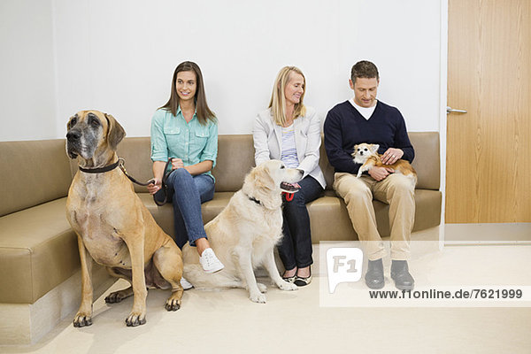 Owners with pet in waiting area†of vet's