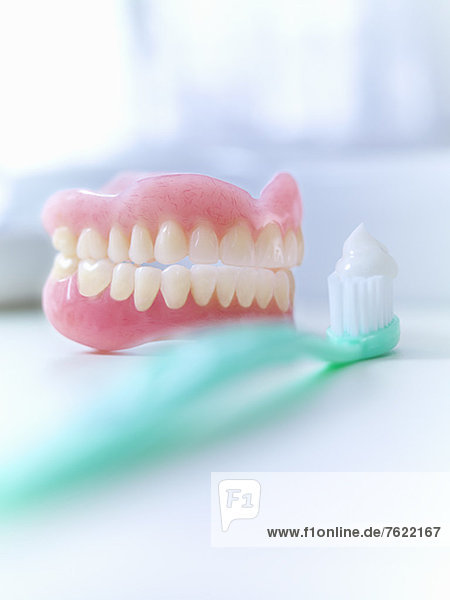 Close up of dentures and toothbrush