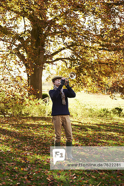 Teenager-Junge spielt Trompete im Freien