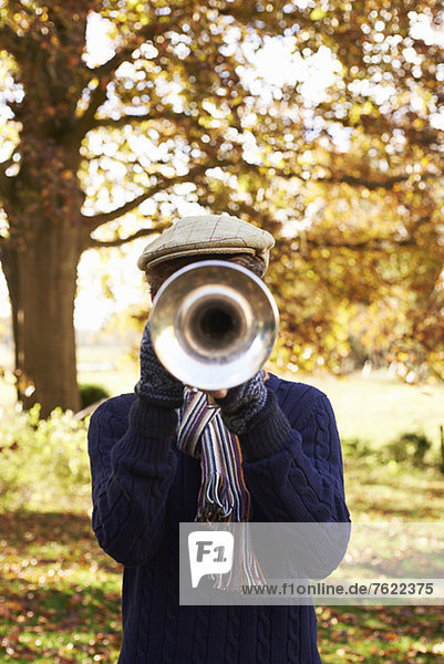 Teenager-Junge spielt Trompete im Freien