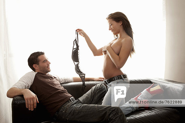 Frau beim Strippen für Freund auf dem Sofa