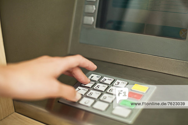 Woman using keypad on ATM