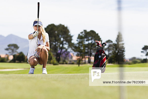 Woman playing golf on course