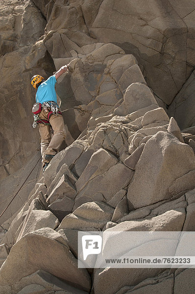 Rock climber scaling jagged cliff