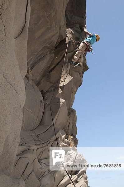 Rock climber scaling jagged cliff