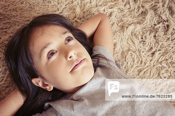 Mädchen liegt auf einem Shag-Teppich