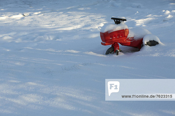 Kinderspielzeug im schneebedeckten Feld