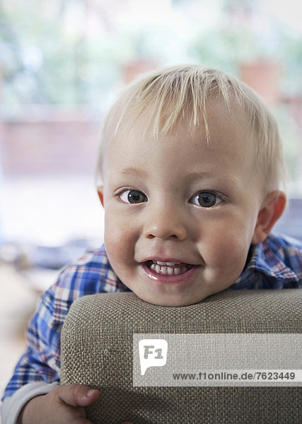 Smiling boy leaning on arm of chair