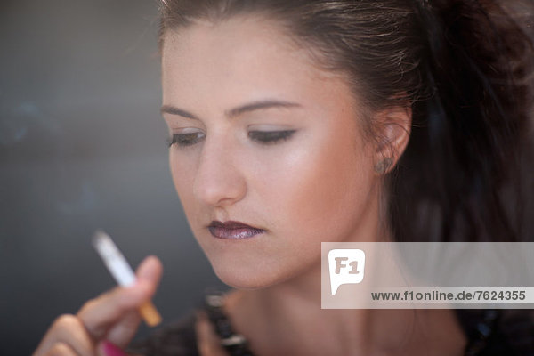 Teenagermädchen in dunklem Make-up rauchend