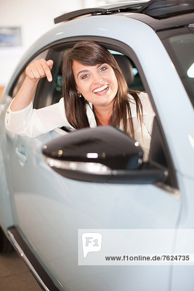 Excited woman pointing to new car