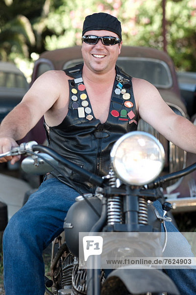 Man in leather vest on motorcycle