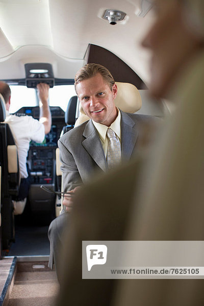 Geschäftsmann im Flugzeug sitzend