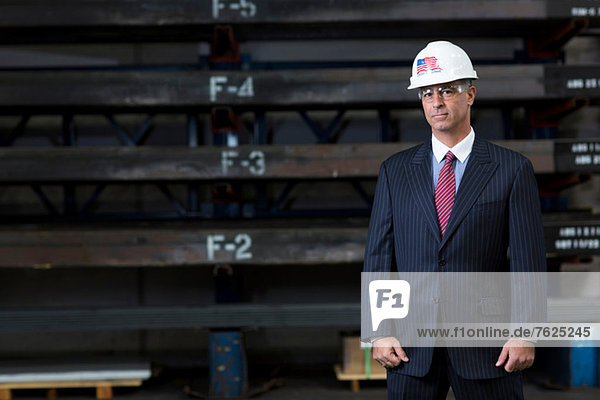 Geschäftsmann im Metallwerk stehend