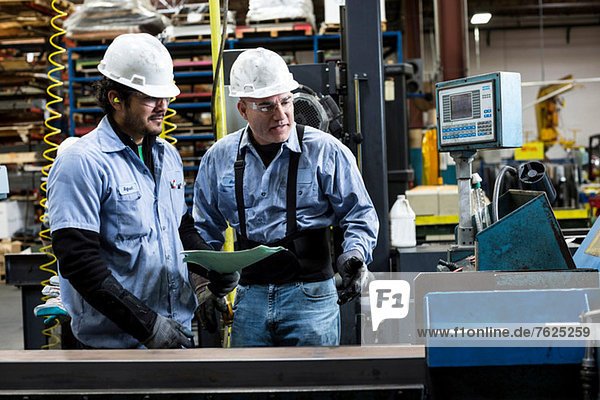 Workers talking in metal plant