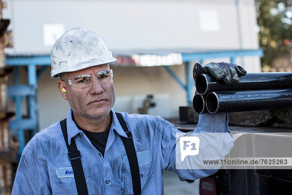 Businessman with pipes in metal plant