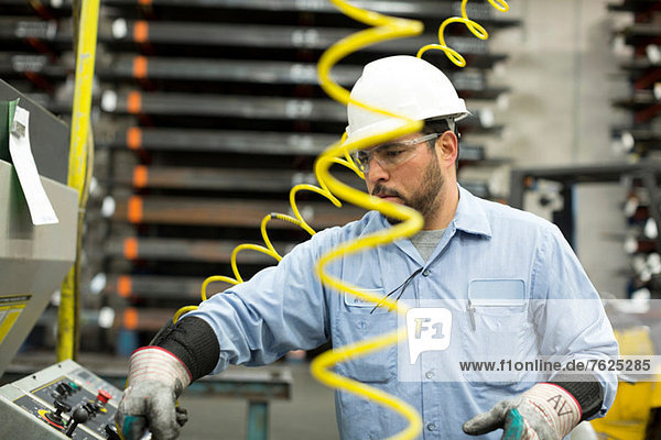 Worker at control panel in metal plant