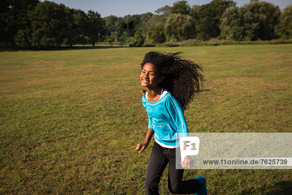 Smiling girl running in field