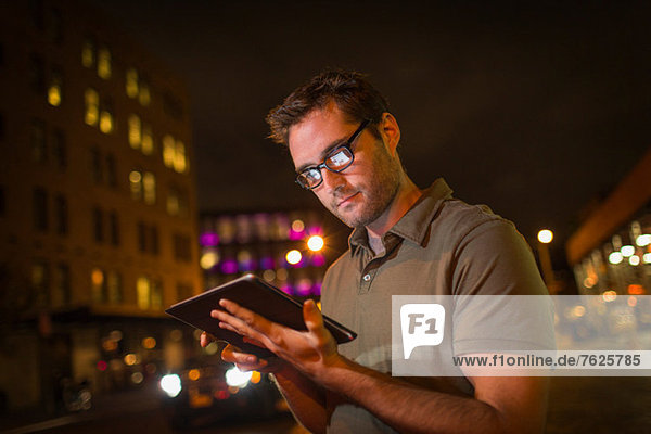 Mann mit Tablet-Computer auf der Stadtstraße
