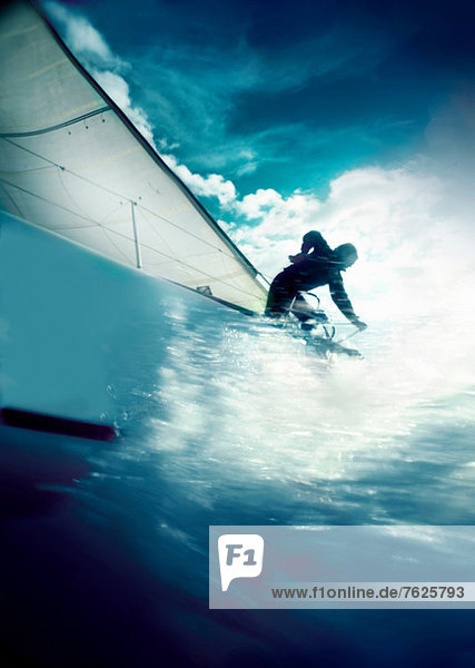 Man trimming sails on yacht in race
