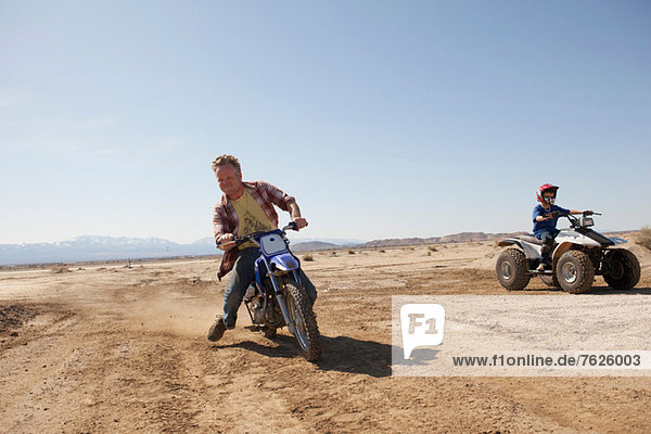 Man riding dirt bike in desert