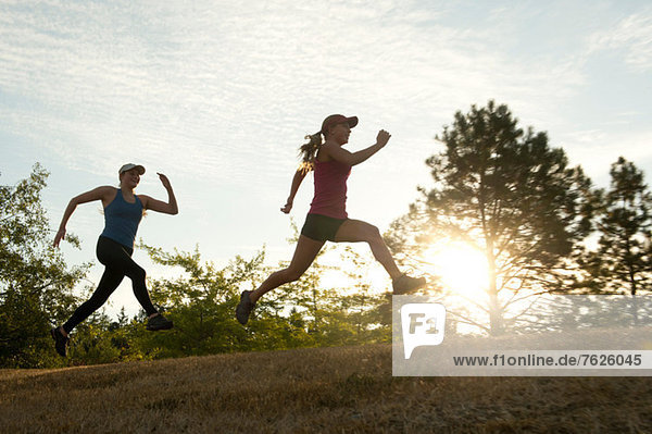 Teenage girls running together in field