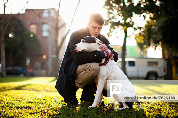 Mann umarmender Hund im Park