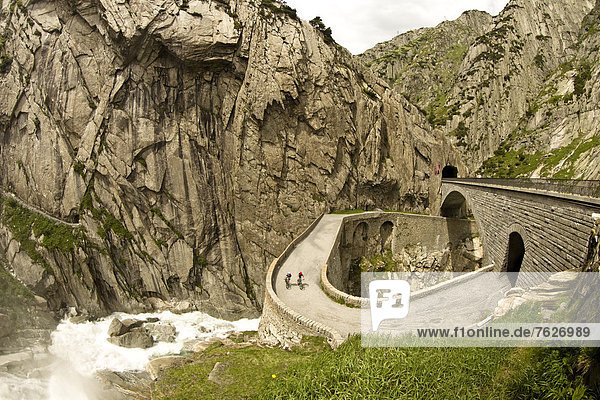 Two cyclists on mountain pass road  Andermatt  Switzerland