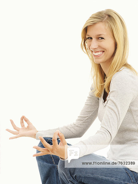 Frau  lächelnd  meditierend  im Schneidersitz