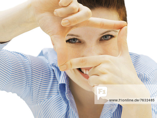Businesswoman looking through her fingers as a frame