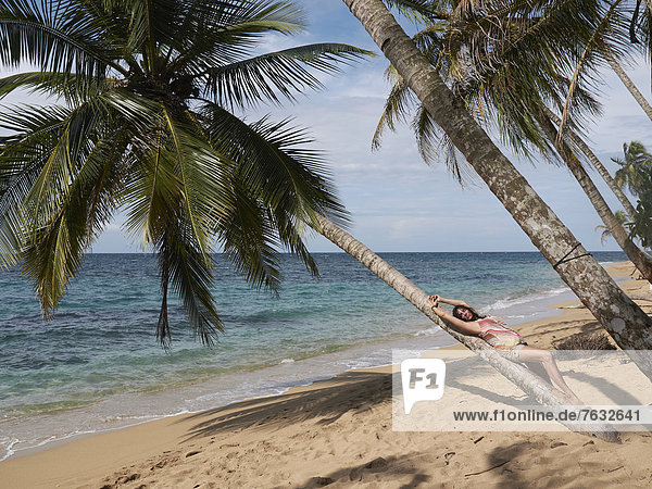 Frau  45  entspannt sich auf einer Palme liegend  Punta Uva  Puerto Viejo de Talamanca  Costa Rica  Zentralamerika