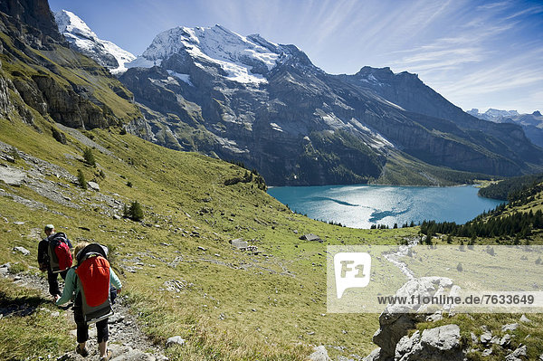Hikers at Oeschinensee  Oeschinen Lake  Bernese Oberland  Canton of Bern  Switzerland  Europe