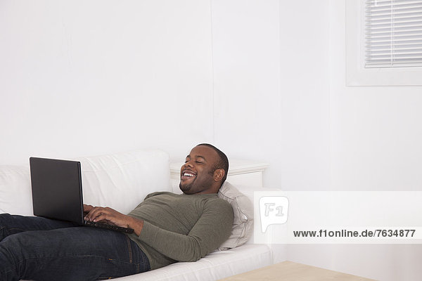 liegend  liegen  liegt  liegendes  liegender  liegende  daliegen  benutzen  Mann  Couch  schwarz  Tablet PC
