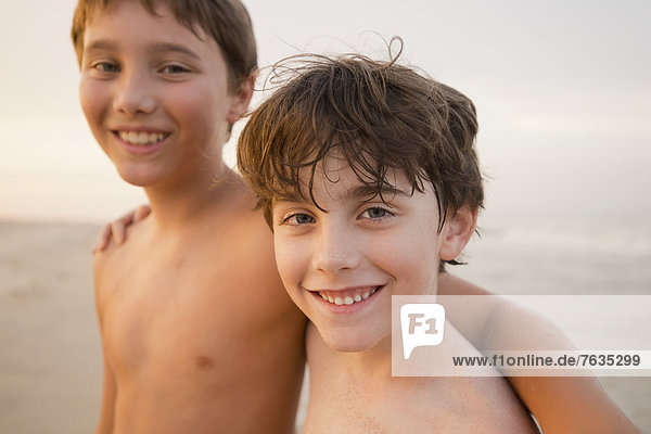 Caucasian boys walking on beach