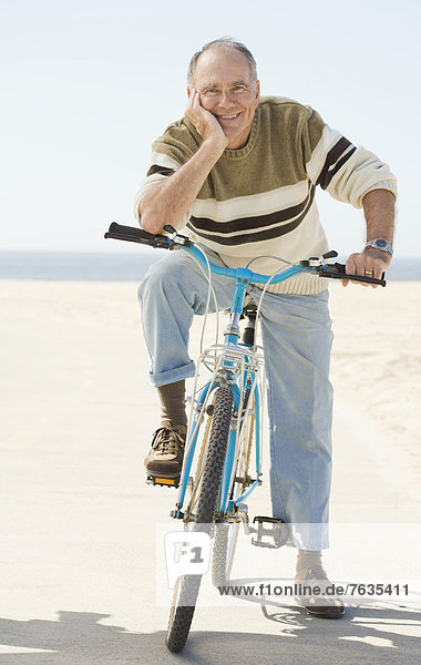 Caucasian older man sitting on bicycle