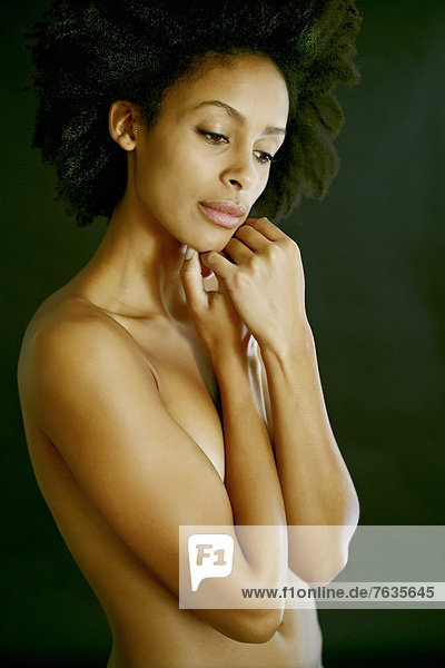 Nude mixed race woman covering her body