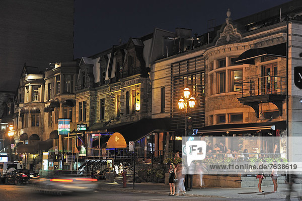 stehend Frau Mann Kurznachricht gehen Dunkelheit Nacht warten Gebäude Straßenlaterne Laterne Restaurant Lampe Laden Fußgänger Kanada unterhalten Montreal Quebec