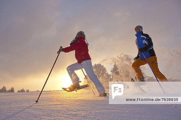Schneeschuh Frau Winter Mann gehen Sonnenuntergang wandern Schnee Wintersport