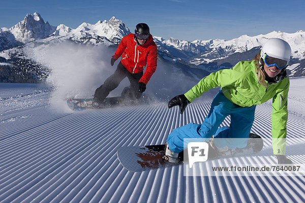 Frau Berg Winter Mann Snowboard Snowboarding Alpen Außenaufnahme Tiefschnee Wintersport
