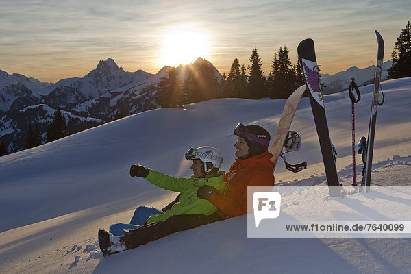 Frau Berg Winter Mann Snowboard Snowboarding Sonnenuntergang schnitzen Alpen Skisport Ski Außenaufnahme Tiefschnee Wintersport