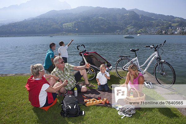 Family  electric bicycles  Flyer  eBike  Pilatus  bicycle  bicycles  bike  riding a bicycle  lake  lakes  canton  LU  Lucerne  Luzern  Vierwaldstättersee  lake Lucene  central Switzerland  Switzerland  Europe  generations  grandparents  parents  children  picnic