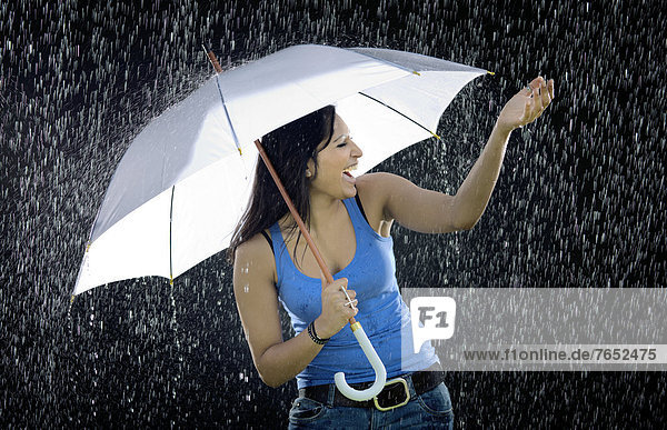 Frau  Fröhlichkeit  Regenschirm  Schirm  halten  weiß  Regen  Indianer  Euphorie  jung