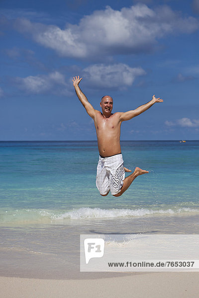 Mann  Fröhlichkeit  Strand  springen  45-50 Jahre  45 bis 50 Jahre  Afrika  Indischer Ozean  Indik  Seychellen