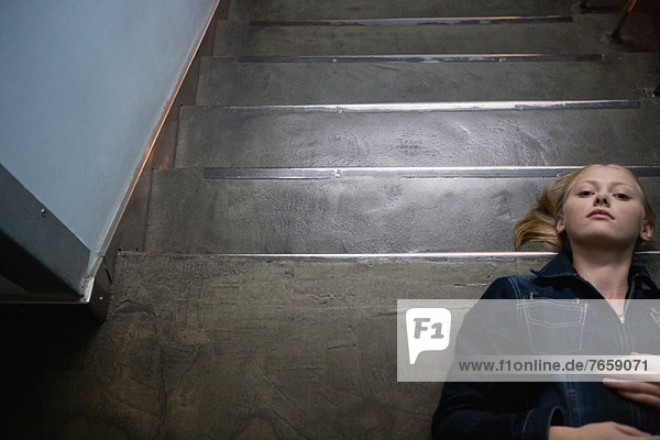 Young woman lying on stairs  portrait
