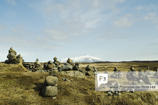 Cairns Vulkangestein auf dem Hintergrund verschneiter Berge Island Gullfoss