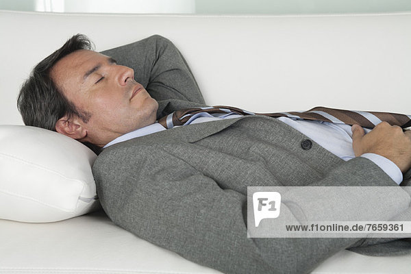 Erwachsener Geschäftsmann schläft auf der Couch