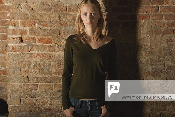 Young woman standing with hands in pockets  portrait