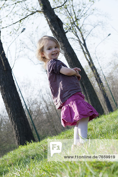 Little girl smiling outdoors  full length portrait